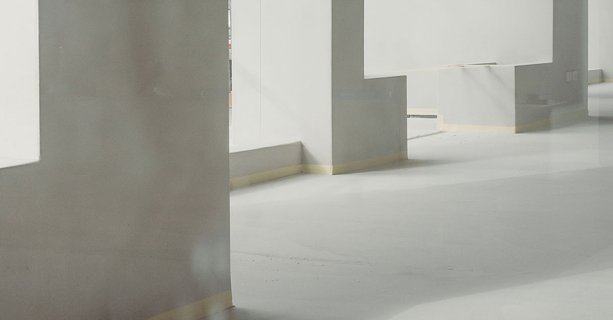 Modern interior showcasing microtopping pros and cons through Terrazzo GraniTech seamless flooring - smooth gray surfaces with integrated steps and columns demonstrating the superior durability, aesthetic appeal, and jointless finish that addresses traditional microtopping limitations with advanced resin-based technology
