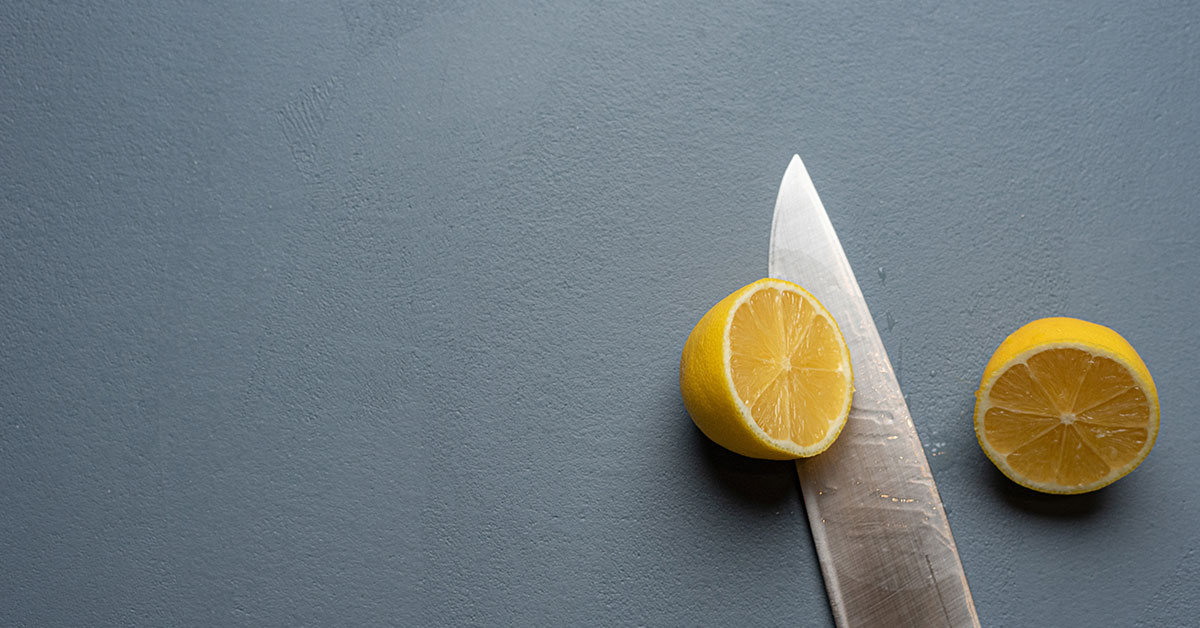 Close-up of blue kitchen wall plaster showing textured surface with knife and lemon slices, demonstrating food-safe plaster wall finish and durability of kitchen plaster application for culinary spaces
