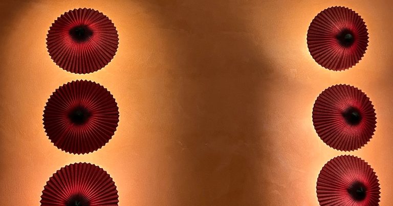 Smooth orange plaster wall with decorative circular elements showing crack-free surface that prevents plaster cracking on walls