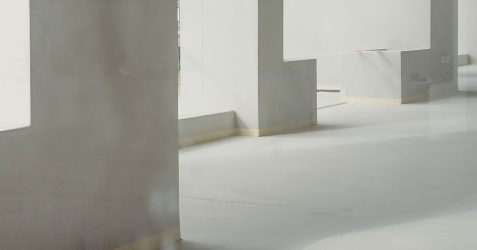 Modern interior showcasing microtopping pros and cons through Terrazzo GraniTech seamless flooring - smooth gray surfaces with integrated steps and columns demonstrating the superior durability, aesthetic appeal, and jointless finish that addresses traditional microtopping limitations with advanced resin-based technology