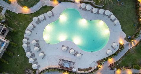 Aerial view of completed pool renovation project featuring Terrazzo GraniTech material on custom-shaped swimming pool and surrounding deck area with resort-style amenities