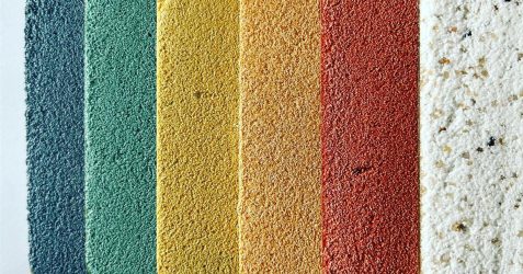 Colorful textured plaster wall finish samples in blue, green, yellow, orange, red, and white, arranged vertically on a neutral background