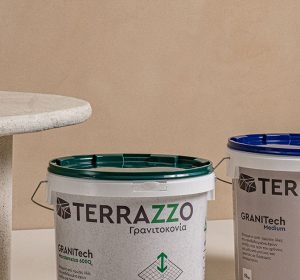 “Terrazzo GraniTech finish on wall and surface next to product buckets – a modern alternative in the gypsum plastering vs cement plastering debate.